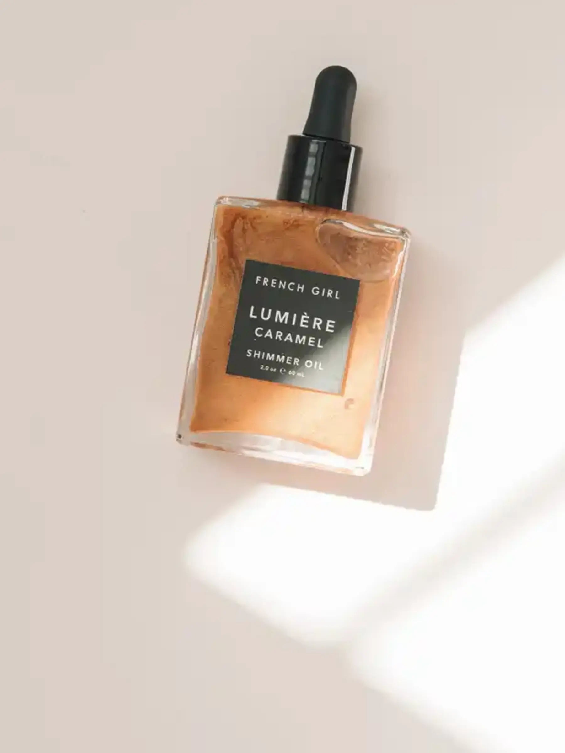 Caramel Shimmer Oil serum bottle with warm glow finish
